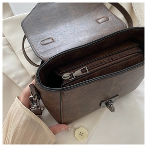 Detail view of the vintage brown leather bag interior with zipper compartment and twist lock