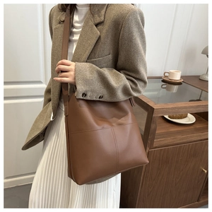Detailed view of caramel brown leather shoulder bag with vertical stitching craftsmanship