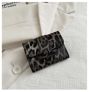 Close-up of leopard print mini flap bag textured with brown and black faux fur patterns