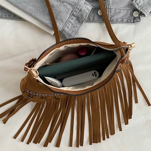 Interior view of brown suede fringe bag showing storage space for daily essentials