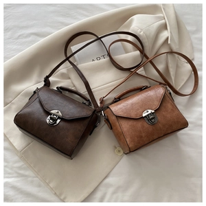 Detailed view of vintage leather crossbody bags in coffee and light brown with metal clasps