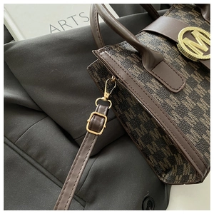 Dettaglio di una borsa di lusso marrone con fibbia in metallo dorato e trama in pelle