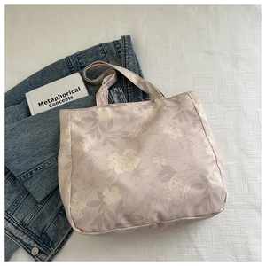 Close-up of floral tote bag with cream flower patterns on soft pink-purple fabric