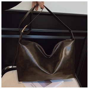 Macro shot of dark brown PU leather texture and golden metal buckle on shoulder bag