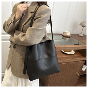 Detail of black large bucket bag showing premium matte texture and cross stitching craft