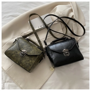 Close-up of vintage square handbags with distressed leather texture and metal locks
