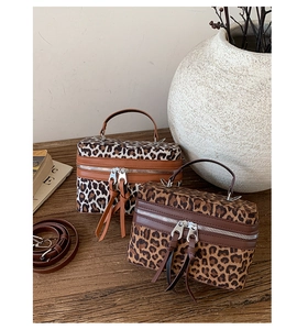 Détail du sac boîte à motif léopard avec bordure en cuir marron et double fermeture
