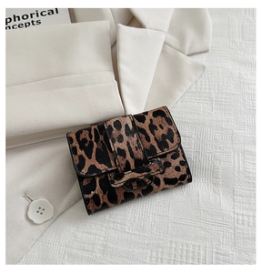 Close-up of leopard print mini square bag on ivory suit showing fine leather texture