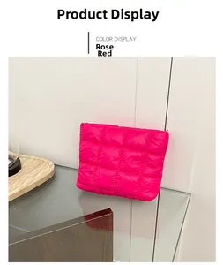 Macro detail of rose red quilted nylon pouch showing large square stitching and zipper
