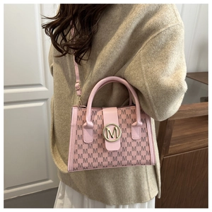 Dettaglio della borsa a tracolla rosa con motivo monogramma e logo M dorato lucido