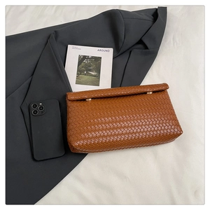 Dettaglio della pochette intrecciata in PU marrone caramello con finiture dorate e misura