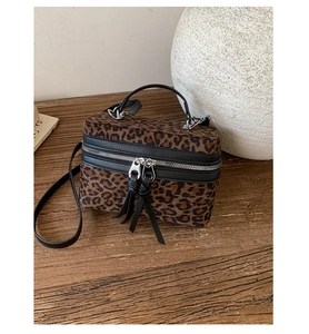 Détail du sac léopard avec fermetures éclair à doubles glands et poignée supérieure noire