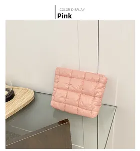 Close-up of pink quilted puffer clutch bag with a soft grid-stitched down-like texture