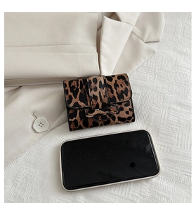 Mini leopard print wallet shown next to a smartphone for size reference and scale
