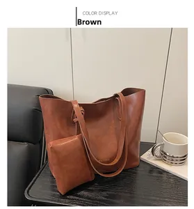 Brown leather tote bag set including a large shopper and matching clutch on a table