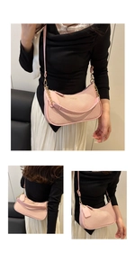 Detailed views of pink textured crescent crossbody bag with gold chain and leather trim