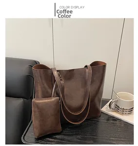 Detail view of large coffee brown tote bag with leather texture and matching small pouch