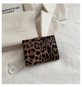 Close-up of leopard print mini wallet with cross-grain texture on white blazer