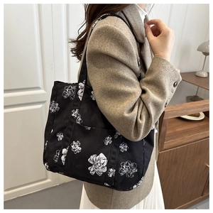 Detail of floral canvas tote bag styled with a beige blazer for an elegant urban look