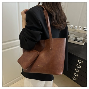Brown vintage tote bag with small pouch shown on model in a modern home setting