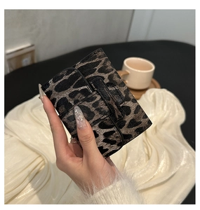 Detailed close-up of stylish leopard print mini card holder wallet in hand