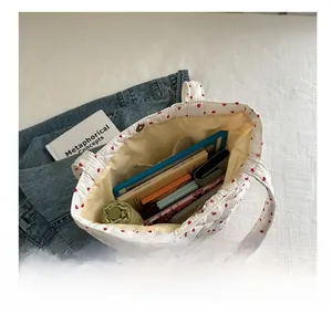 Large capacity quilted tote bag showing interior storage for umbrella, wallet and books