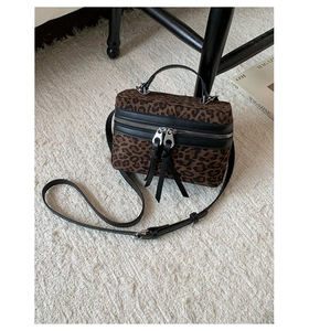 Détail du sac boîte imprimé léopard sur fausse fourrure blanche avec fermetures éclair