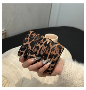 Close-up of stylish leopard print mini square purse held by hand for a trendy look