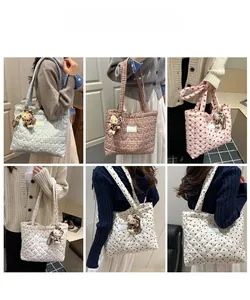 Detail showing various quilted tote bags with heart patterns and bear charms