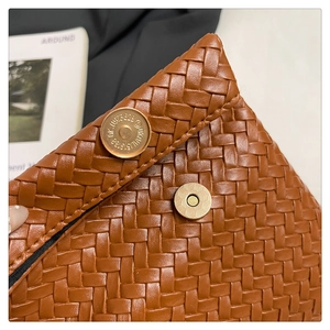 Vista dettagliata della borsa in similpelle intrecciata marrone con chiusura magnetica