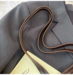Close-up of durable dark brown leather shoulder straps with premium double-stitched details
