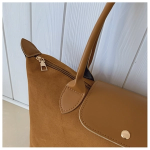 Detailed close-up of camel tote bag showing suede texture and gold metallic hardware