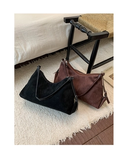 Détail de sacs hobo en daim noir et marron avec bandoulières en cuir réglables