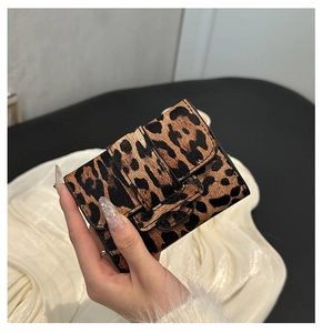 Macro shot of stylish leopard print mini wallet with textured synthetic material and flap closure