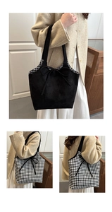 Detail of reversible tote bag showing black side and classic gingham check pattern