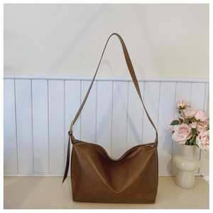 Detail of a dark brown vintage shoulder bag with textured faux leather and gold hardware