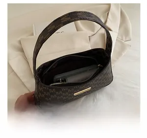 Close-up of vintage brown underarm bag showing large capacity for phone and wallet
