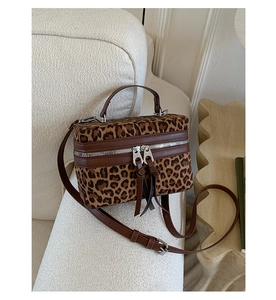 Détail du sac vanity à imprimé léopard avec poignées en cuir et double zip argenté