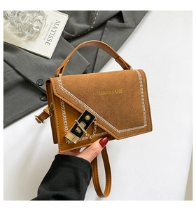 Détails du sac bandoulière bicolore avec rabat en daim et surpiqûres blanches en V