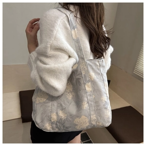 Detail of floral canvas tote bag showing side pocket and spacious design on shoulder