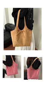 Detail view of double-sided tote bag featuring camel faux suede and red plaid patterns