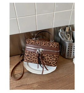 Vue détaillée du sac boîte léopard avec garniture en cuir brun et fermetures à glands