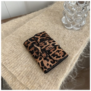 Detail view of mini leopard print card holder with textured finish and layered flap
