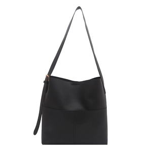 Minimalist black faux leather tote bag with vertical stitching and adjustable strap