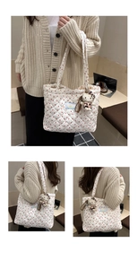 Close-up of heart print quilted tote bag with cute cat charm in a lifestyle setting