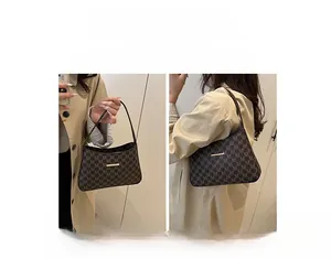 Detail view of brown monogram shoulder bag showing versatile hand-carry and shoulder modes