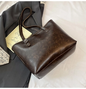 Detail of vintage dark brown tote bag with premium leather grain on a minimalist background