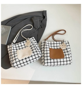 Detail of houndstooth tote bags with faux leather trim and cute cat charms