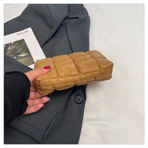 Close-up of caramel quilted nylon pouch showing soft cloud texture and grid stitching