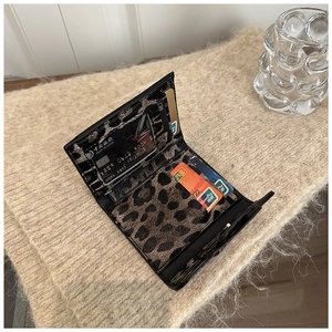Detail view of leopard print mini wallet featuring multiple card slots and card organization